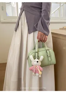Dettaglio della mini borsa bowling verde pistacchio con un dolce ciondolo a coniglio