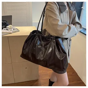 Close-up of a large coffee brown tote bag in glossy wrinkled faux leather texture