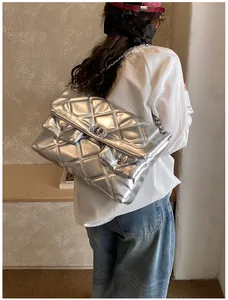 Silver quilted chain bag shown on model highlighting its large size and metallic finish