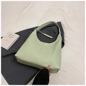 Détail du sac cabas en cuir vert menthe avec motif litchi et bandoulière large