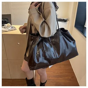 Detail view of the glossy dark brown large tote bag showing high-shine texture and size