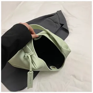 Détail du sac cabas en cuir grainé avec fermoir magnétique et étiquette de marque