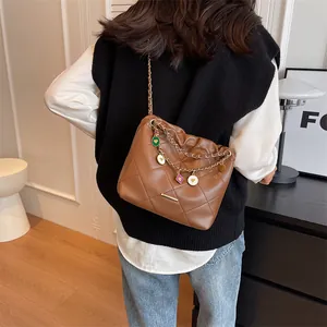 Sac seau matelassé marron avec chaîne dorée et pendentifs en émail colorés