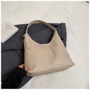 Vue détaillée du sac cabas en cuir grainé abricot sur un décor blanc minimaliste