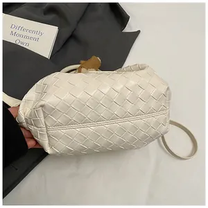 Détail du sac seau tressé blanc avec motif Intrecciato et doublure en peluche