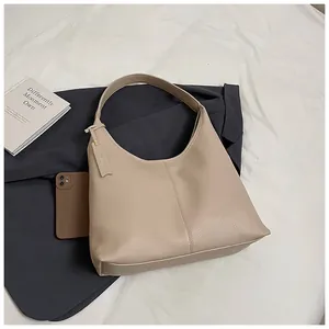Détail du sac hobo beige avec texture grainée litchi sur fond lifestyle