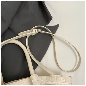 Gros plan détaillé d'un sac seau tressé crème avec des finitions en argent brillant