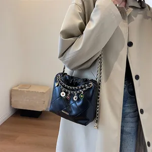 Sac seau noir matelassé avec bandoulière chaîne et breloques colorées avec trench