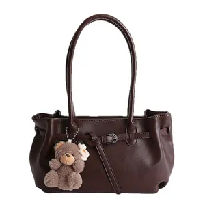 Deep brown faux leather tote bag with a long shoulder strap and cute plush bear charm