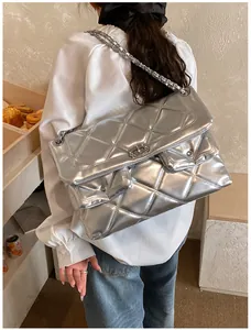 Detail of silver quilted bag showing metallic texture and decorative front pockets
