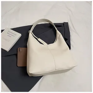 Détail du cuir grainé litchi sur ce sac fourre-tout beige à la silhouette hobo chic