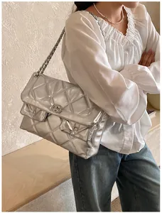 Close-up of a silver quilted chain bag featuring a metallic mirror finish and vintage turn-lock