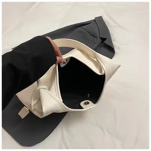 Détail du fermoir magnétique et de la doublure en tissu noir du grand sac cabas blanc