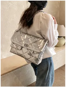 Detailed view of large quilted silver chain bag worn by model showing its size and fit