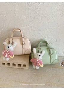 Dettaglio delle borse Boston beige e verde menta con ciondoli a forma di orsetto