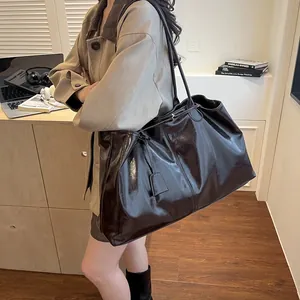 Chic dark brown glossy patent leather tote bag for women showing spacious commuter style