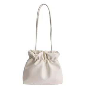 Minimalist ivory drawstring bucket bag made of soft PU leather with elegant pleats