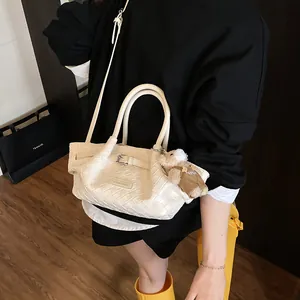 Sac seau tissé beige chic avec breloque d'ours et bandoulière pour un usage quotidien