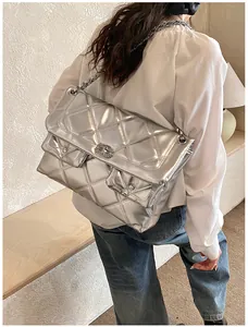 Detail of silver quilted chain bag with double pockets and metallic finish for daily use