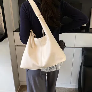 Sac fourre-tout chic en cuir beige grainé avec une forme de croissant souple