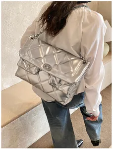 Detailed close-up of a silver quilted chain bag with dual flap pockets and metallic finish