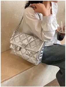 Detail of silver metallic quilted chain bag featuring classic diamond patterns and locks
