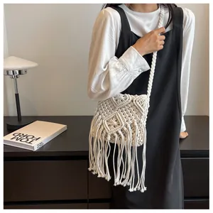 Detail of white handmade macrame crossbody bag with fringe tassels and woven texture
