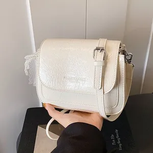 Minimalist creamy white crossbody phone bag with crinkle texture and pearl lace charm