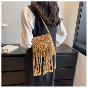 Detail of bohemian straw bag with diamond knit pattern and extra long fringe tassels