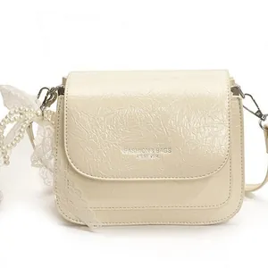Chic cream crossbody phone bag with ruffled leather, lace details and pearl strap