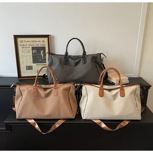 Drei minimalistische Reisetaschen in Grau, Khaki und Creme mit Ledergriffen und Schultergurt