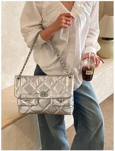Detail of silver quilted handbag with chain strap and dual front pockets