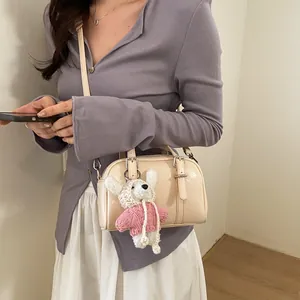 Borsa Boston chic in pelle verniciata beige con ciondolo peluche e tracolla fine