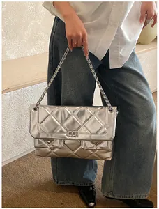 Close-up of silver quilted chain bag with double front pockets and rhinestone buckle