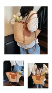 Detail view of woven straw tote bag featuring brown leather trim and spacious interior
