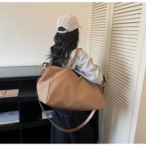 Detail der gewebten Textur und Ledergriffe einer großen khakifarbenen Shopper-Tasche