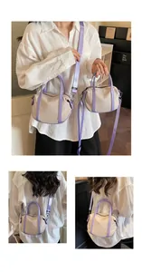 Detail view of canvas crossbody bag with purple leather trim and adjustable shoulder strap