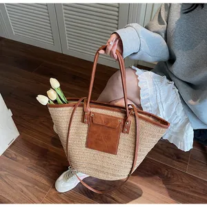 Detail of hand-woven straw tote bag with brown faux leather pocket and durable shoulder straps
