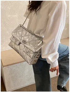 Detail of silver quilted chain bag featuring metallic finish and dual front pockets