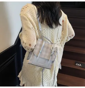 Bolso bandolera a cuadros azules y grises con lazo de encaje en un modelo