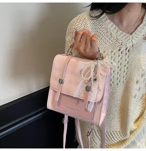 Detalle de bolso a cuadros rosa con lazo de encaje y colgante de perlas refinado