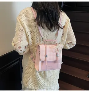 Detalle de mochila a cuadros rosa con lazo de encaje blanco y correas decorativas