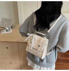 Detalle de mochila vintage de cuadros beige con lazo de encaje y correas con hebilla