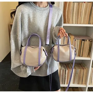Detail view of two beige canvas bags with lilac trim in large and small sizes