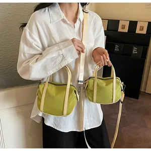 Detail of green canvas crossbody bag with adjustable straps and zipper closure