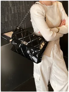 Close-up of a large black quilted faux leather shoulder bag with silver chain strap