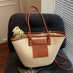 Straw tote bag with brown faux leather trim and daisy decoration on a velvet chair