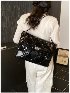 Rear view of an oversized black quilted patent leather bag with silver chain straps