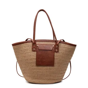 Fashionable straw tote bag with brown leather trim and handles for beach vacations