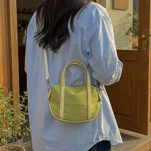 Minimalist light green canvas crossbody handbag with top handles and white shoulder strap